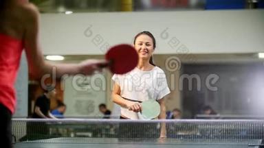 打<strong>乒乓球</strong>。 年轻微笑的女人打<strong>乒乓球</strong>。 那个女人错过了球，就去捡球